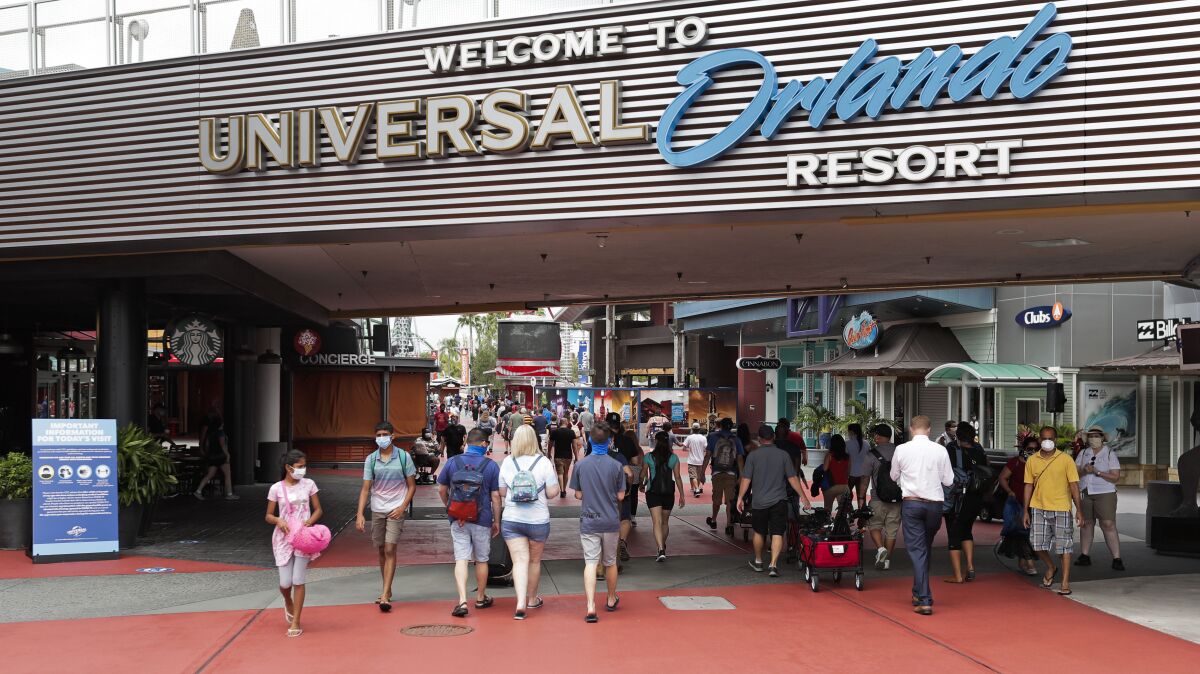 FILE—In this June 3, 2020 file photo, visitors arrive at Universal Studios, in Orlando, Fla. Amusement parks of all sizes are adjusting everything from selling tickets to serving meals while trying to reassure the public and government leaders that they're safe to visit amid the coronavirus crisis and warnings against large gatherings. (AP Photo/John Raoux, File)