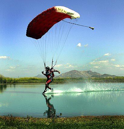 Clint Clawson drags his toes in a pond while performing a freestyle swooping move at Perris Valley Skydiving in Perris, a popular site for the advanced skydiving maneuver called swooping.