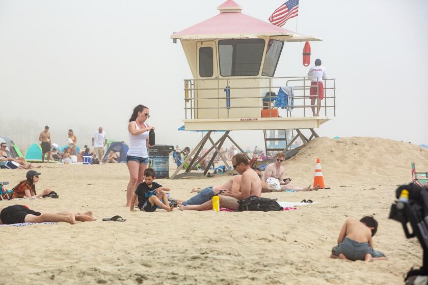 HUNTINGTON BEACH, CA - APRIL 26: After being on lockdown for over a month people begin to congregate at Huntington Beach during the coronavirus pandemic on Sunday, April 26, 2020 in Huntington Beach, CA. (Jason Armond / Los Angeles Times)