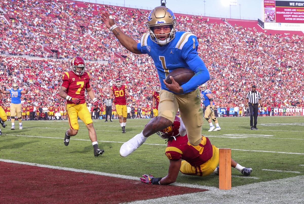 UCLA quarterback Dorian Thompson-Robinson beats USC linebacker Ralen Goforth at Los Angeles Memorial Coliseum. 