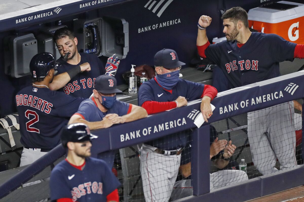 Boston Red Sox's Xander Bogaerts (2) celebrates with teammates in the dugout after hitting a fifth-inning solo home run in a baseball game against the New York Yankees, Sunday, Aug. 2, 2020, at Yankee Stadium in New York. (AP Photo/Kathy Willens)
