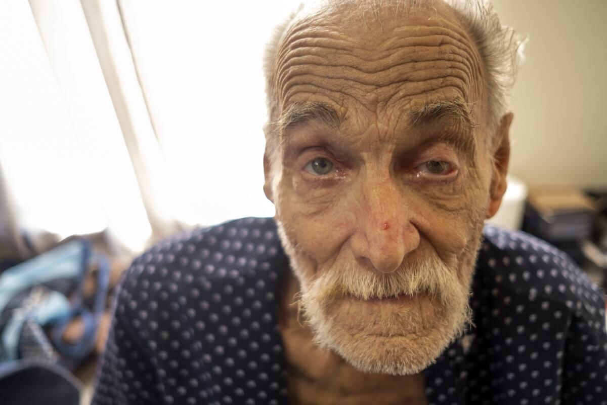 Richard Dever, 82, sits inside his room in the SRO "Madison Hotel" on Friday, Dec. 9, 2022, in Los Angeles