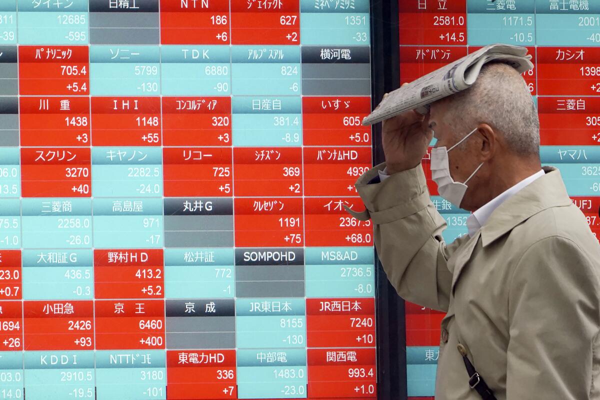 A man walks past an electronic board showing Japan's Nikkei 225 index in Tokyo on Monday.