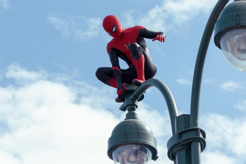 Spider-Man balancing on top of a street lamp