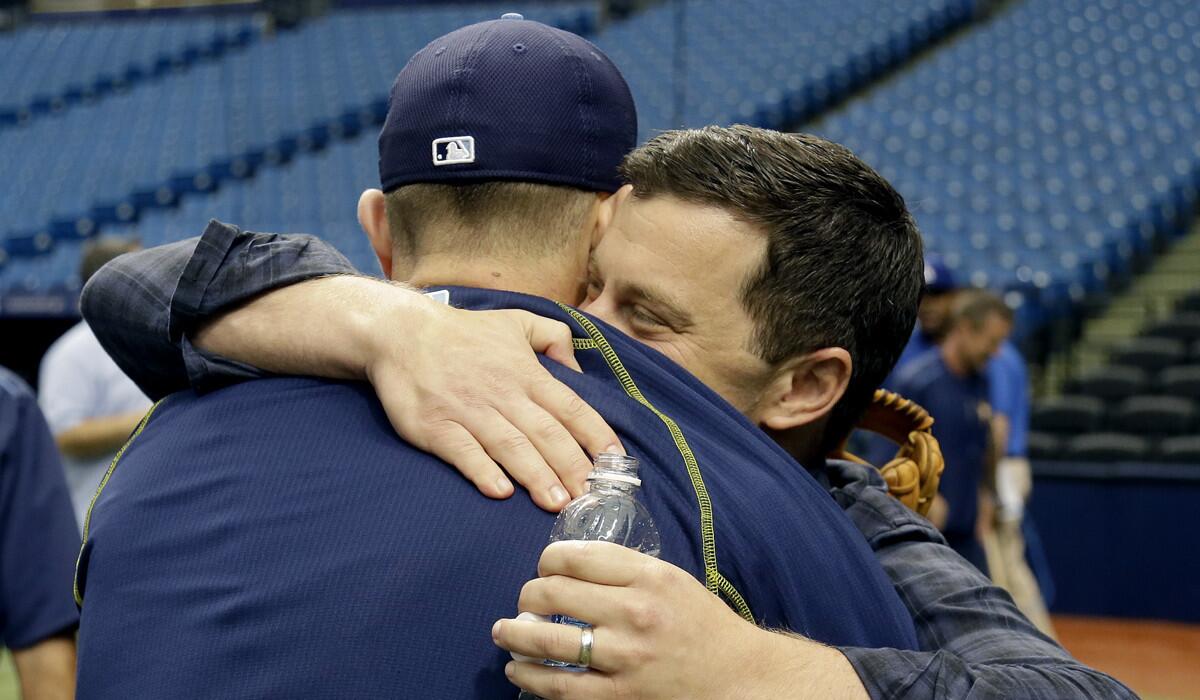 Andrew Friedman, right, Dodgers' president of baseball operations, hugs Tampa Bay Rays' Evan Longoria before the game on Tuesday.