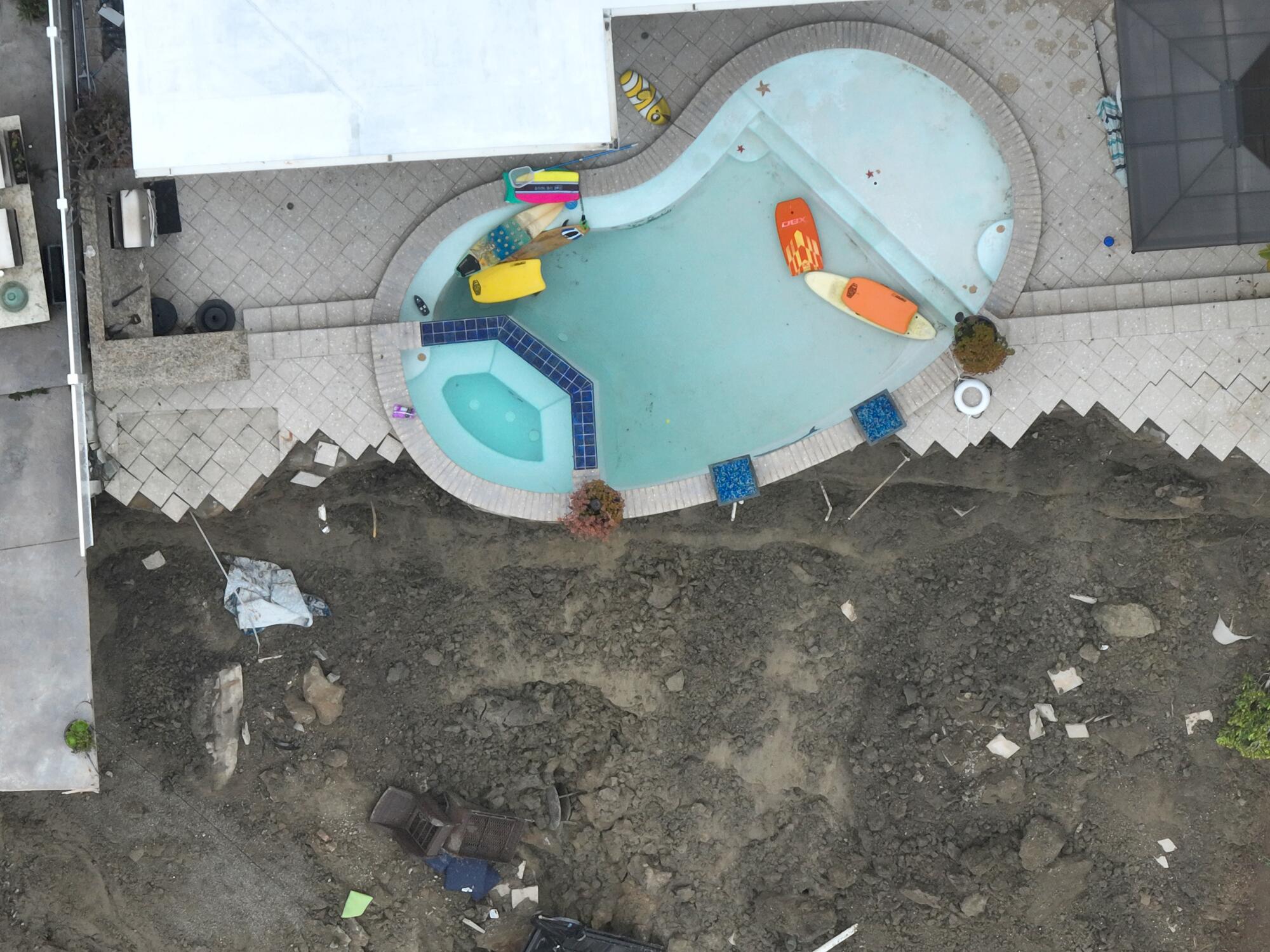 A pool was mostly drained to prevent more movement after four cliff-side, ocean-view apartment buildings were evacuated 