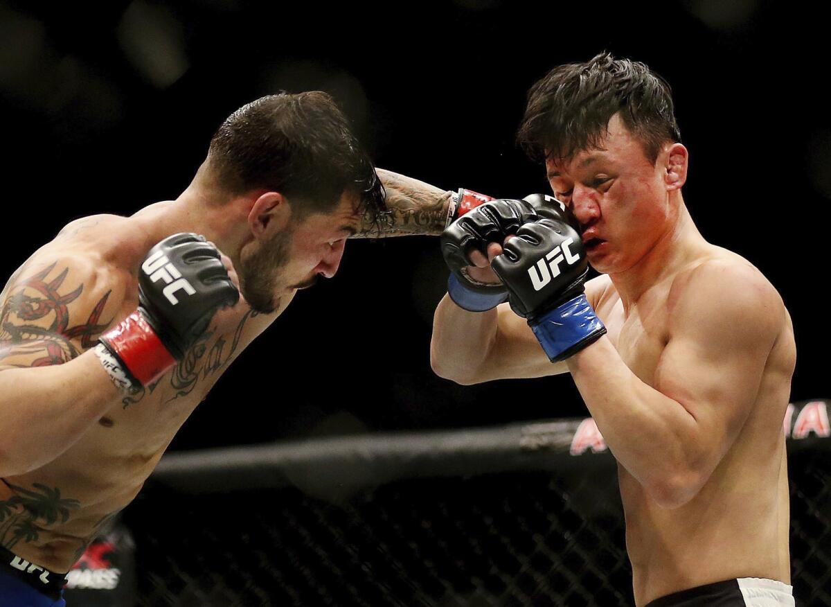 Cub Swanson, left, connects with a punch to the face of Doo Ho Choi during their featherweight bout at UFC 206 in Toronto.