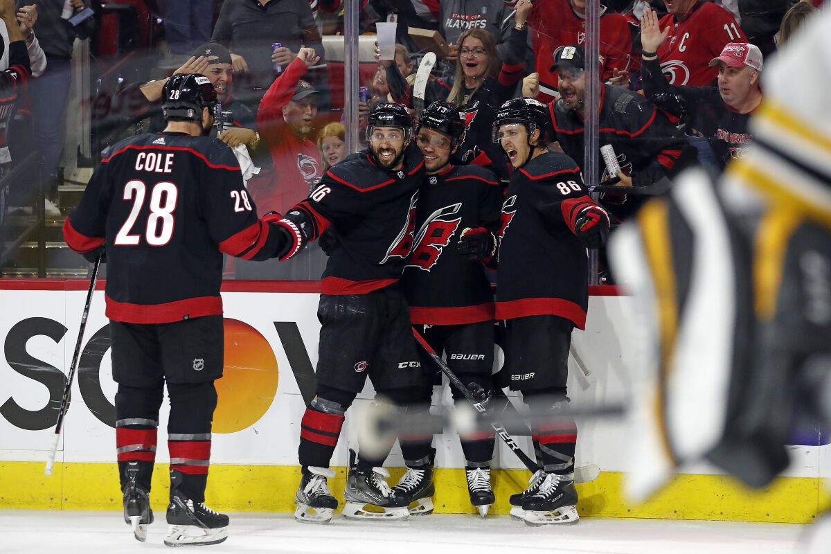 Carolina Hurricanes' Max Domi, center, celebrates his second goal of the period with teammates Vincent Trocheck (16), Teuvo Teravainen (86) and Ian Cole (28) during the second period of Game 7 of an NHL hockey Stanley Cup first-round playoff series against the Boston Bruins in Raleigh, N.C., Saturday, May 14, 2022. (AP Photo/Karl B DeBlaker)