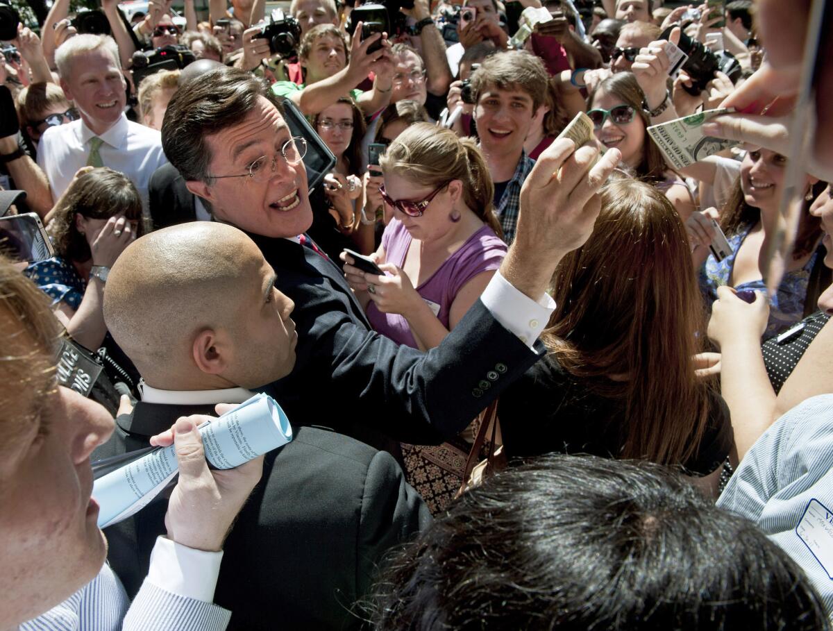 Comedian Stephen Colbert collects cash donations for his Political Action Committee on the sidewalk in front of the Federal Election Commission in Washington, D.C. in 2011.