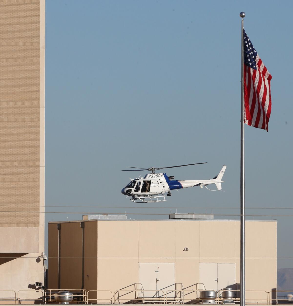 A helicopter flies over a veterans' medical clinic in West Texas on Tuesday during the search for a gunman.