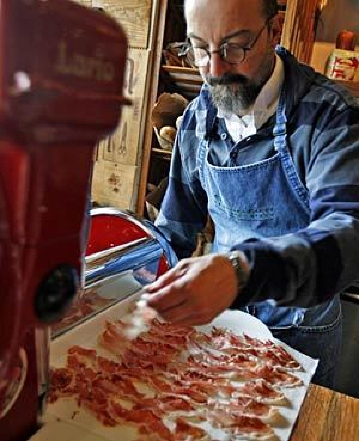 DELICACY: Owner Norbert Wabnig of the Cheese Store of Beverly Hills with jamón ibérico, a recent specialty import to the U.S.
