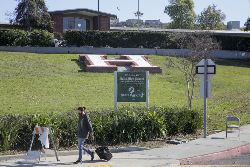 Helix Charter High School in La Mesa is closed Wednesday and will be for a few days because of COVID-related staff shortages as a teacher at the school walks by. She said she was taking a break to eat lunch with her son who is home remote learning. photo by Bill Wechter