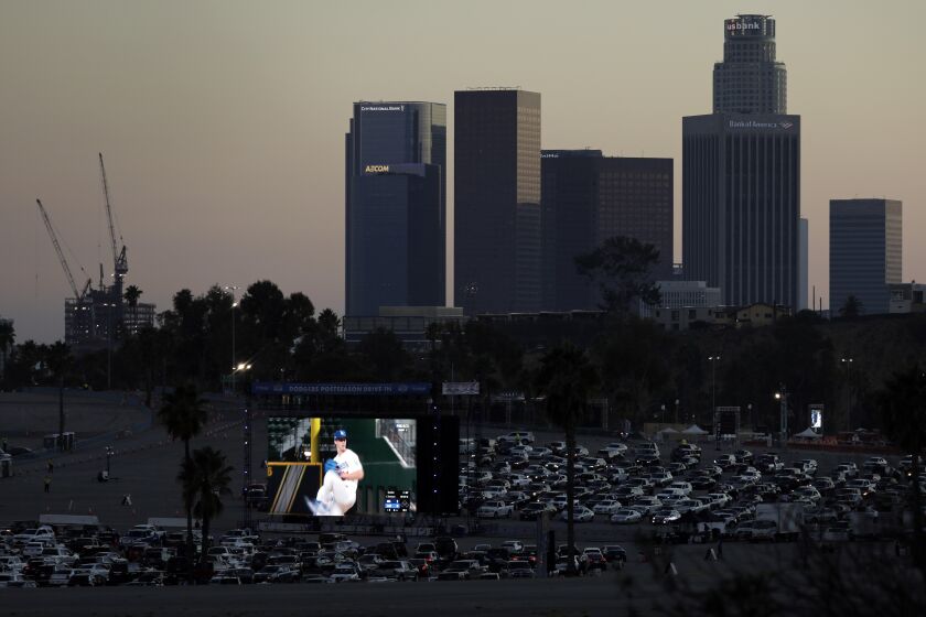 LOS ANGELES, CA - OCTOBER 12: Fans drive into Dodger Stadium on Monday, Oct. 12, 2020 in Los Angeles, CA for a drive-in viewing party for the National League Championship Series against the Atlanta Braves in Arlington, Texas. (Myung J. Chun / Los Angeles Times)