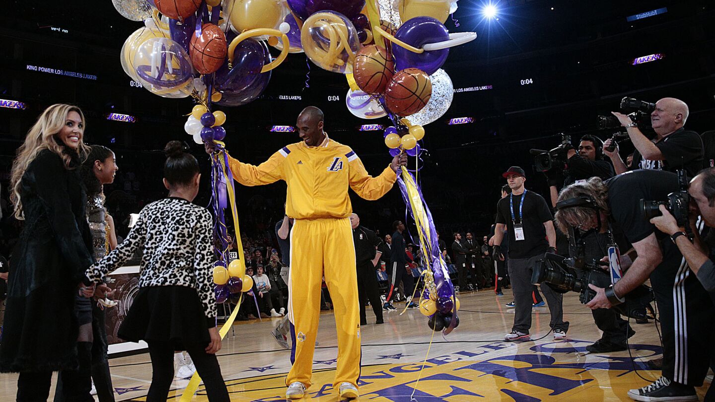 Kobe Bryant is gifted a passel of balloons as his daughter Gianna, right, wife Vanessa and daughter Natalia join him for a ceremony celebrating his passing of Michael Jordan as the third leading scorer in NBA history before a game against the OKC Thunder at Staples Center on Dec. 19, 2014.