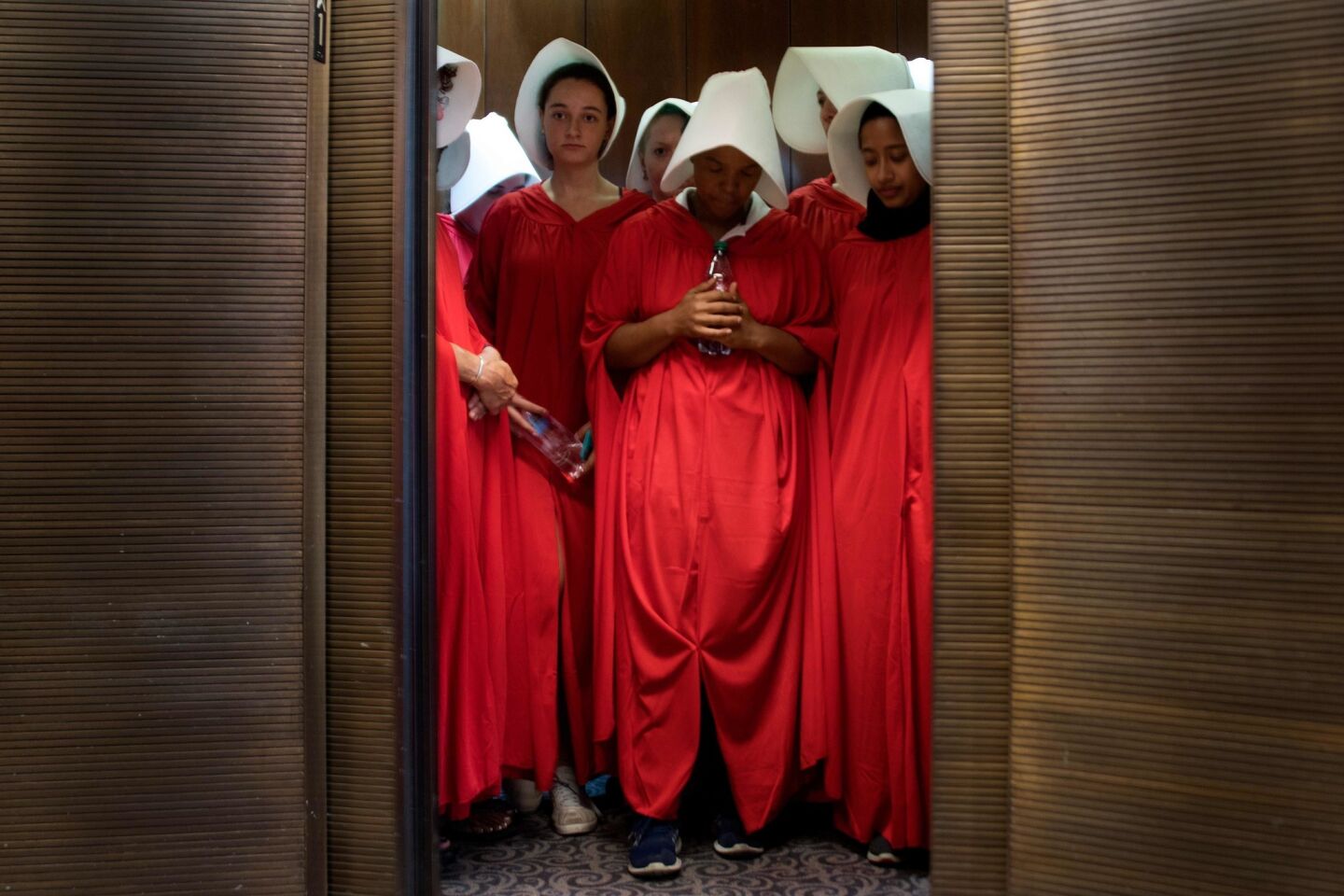 Women dressed as characters from the novel-turned-TV series "The Handmaid's Tale" stand in an elevator at the Hart Senate Office Building as Supreme Court nominee Brett Kavanaugh starts the first day of his confirmation hearings.