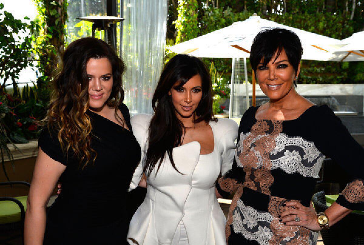 Kim Kardashian is flanked by sister Khloe Kardashian, left, and mom Kris Jenner at DuJour magazine's spring issue celebration in Beverly Hills.