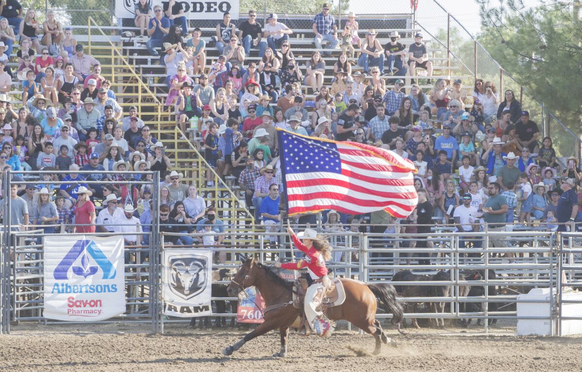 Miss Rodeo California Morgan Laughlin circles the ring while carrying the American flag at the Ramona Rodeo.