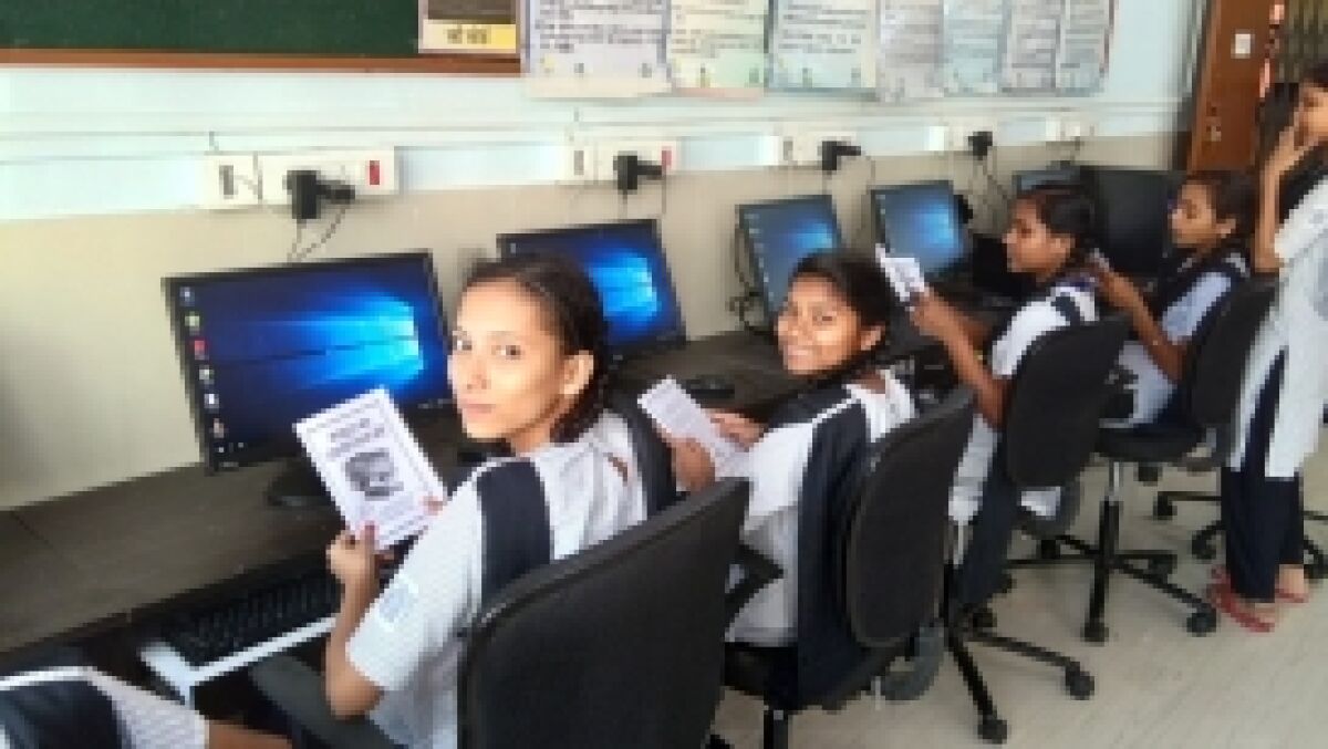 Students look at Jaiv Doshi's computer basics manual 