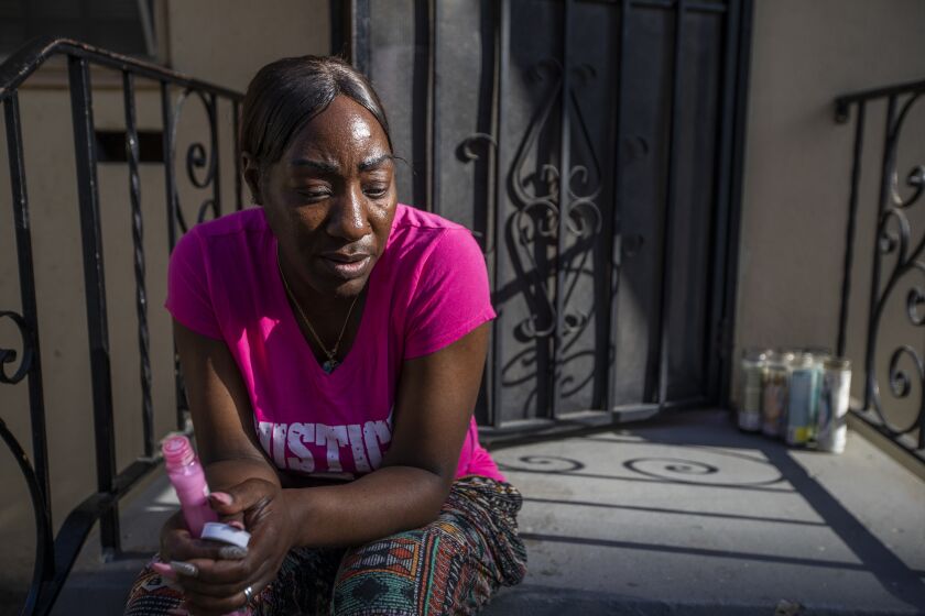 LOS ANGELES, CA MAY 29, 2021: Kawana Anderson, 44, sits on her front porch of her home in Los Angeles, CA MAY 29, 2021. Kawana's son - John Michael Givan Jr., 16, was walking on the sidewalk shortly before 10 p.m. on Sept. 10, 2019, when a vehicle approached and he was shot. The case remains unsolved. Kawana says she continues to be proud of her son each day, but she constantly wonders why him, why her son? She consoles others experiencing the death of a loved one. In private, she tells herself that she has to move on, to live."I don't try to use my son as an excuse to not do something or do something that I should not do," she said. (Francine Orr/ Los Angeles Times)