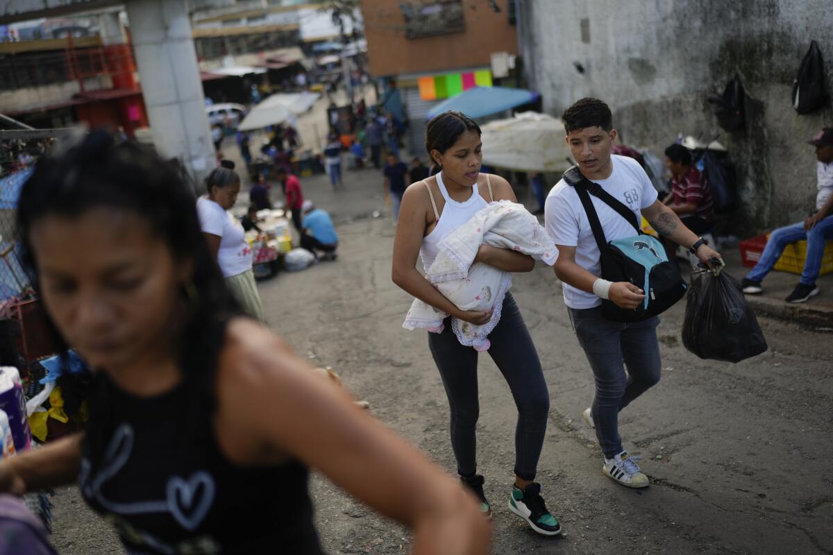 Vecinos caminan por el vecindario de Petare en Caracas, Venezuela, el martes 16 de julio de 2024. (AP Foto/Ariana Cubillos)
