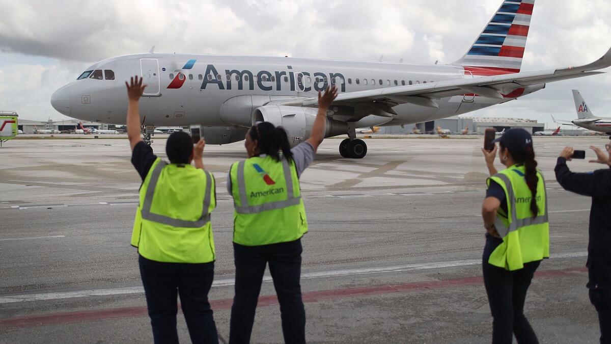 Employees watch as American Airlines Flight 903 prepares for takeoff on Sept. 7, 2016, becoming the first commercial flight from Miami to Cuba in 55 years.