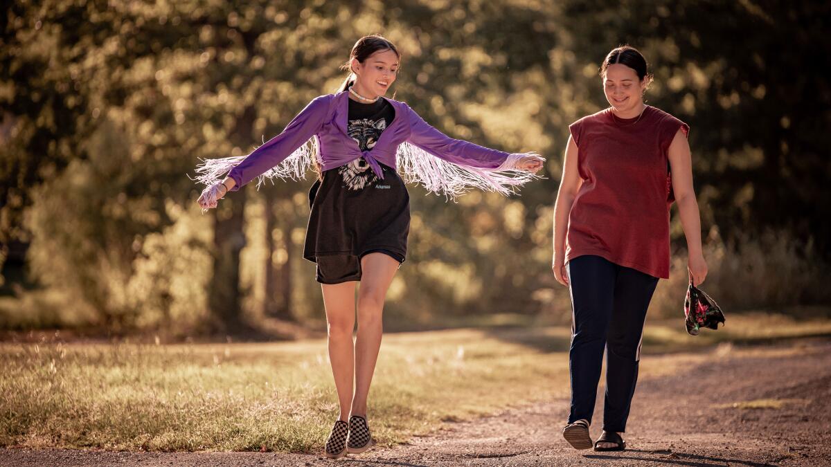 Two people walk in a scene from "Fancy Dance."