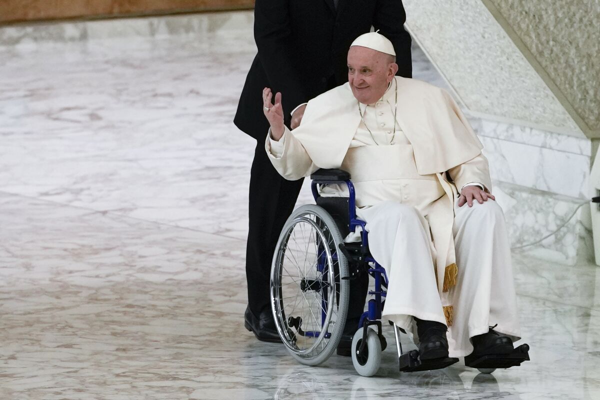 FILE - Pope Francis arrives in a wheelchair to attend an audience with nuns and religious superiors in the Paul VI Hall at The Vatican, May 5, 2022. Pope Francis may postpone a planned visit to Lebanon next month due to health reasons, Lebanese Minister of Tourism Walid Nassar said Monday, May 9, 2022. The pope is known to be suffering acute knee pain that has greatly curtailed his mobility in recent months. (AP Photo/Alessandra Tarantino, File)