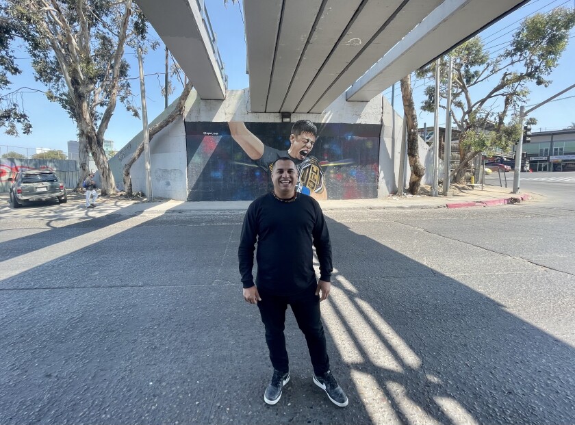 Mode Orozco, 39, posa frente al mural que pintó en homenaje a Brandon Moreno en Tijuana
