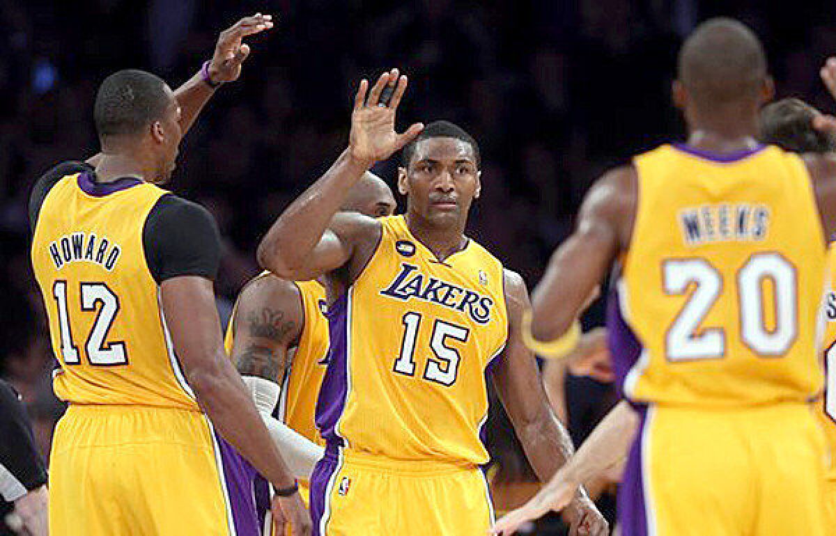 Metta World Peace receives high-fives from his teammates after making a basket during the Lakers' 111-107 victory over the Portland Trail Blazers.
