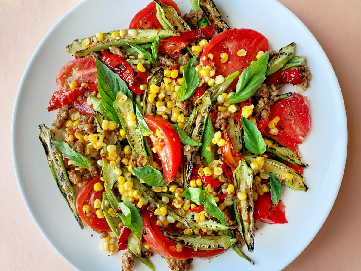 Okra and corn salad with tomato and fresh basil leaves