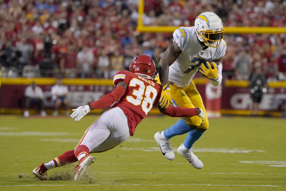 Chargers tight end Gerald Everett (7) runs after a catch as Chiefs cornerback L'Jarius Sneed (38) pursues.