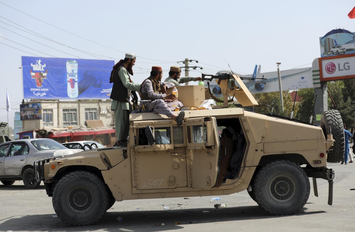 Taliban fighters in an armored vehicle at Kabul's airport