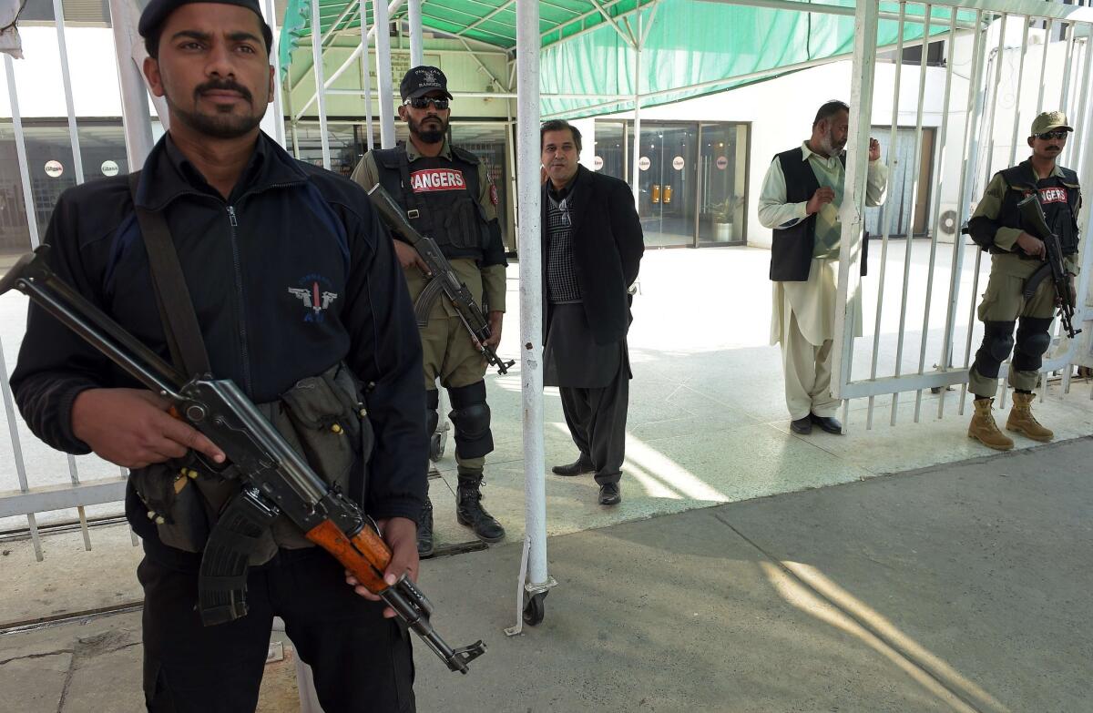 Security agents stand guard at the main entrance of the parliament building in Islamabad, Pakistan, on Tuesday as legislators approved a constitutional amendment granting jurisdiction to military courts in terrorism cases.