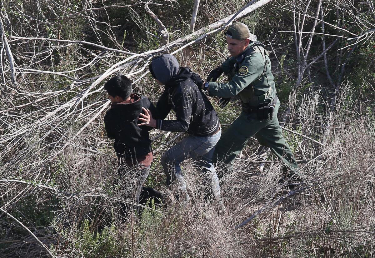 A U.S. Border Patrol agent detains undocumented juvenile immigrants near the U.S.-Mexico border on Dec. 10, 2015, at La Grulla, Texas. The number of unaccompanied minors and families crossing the border from Central America has surged in recent months.