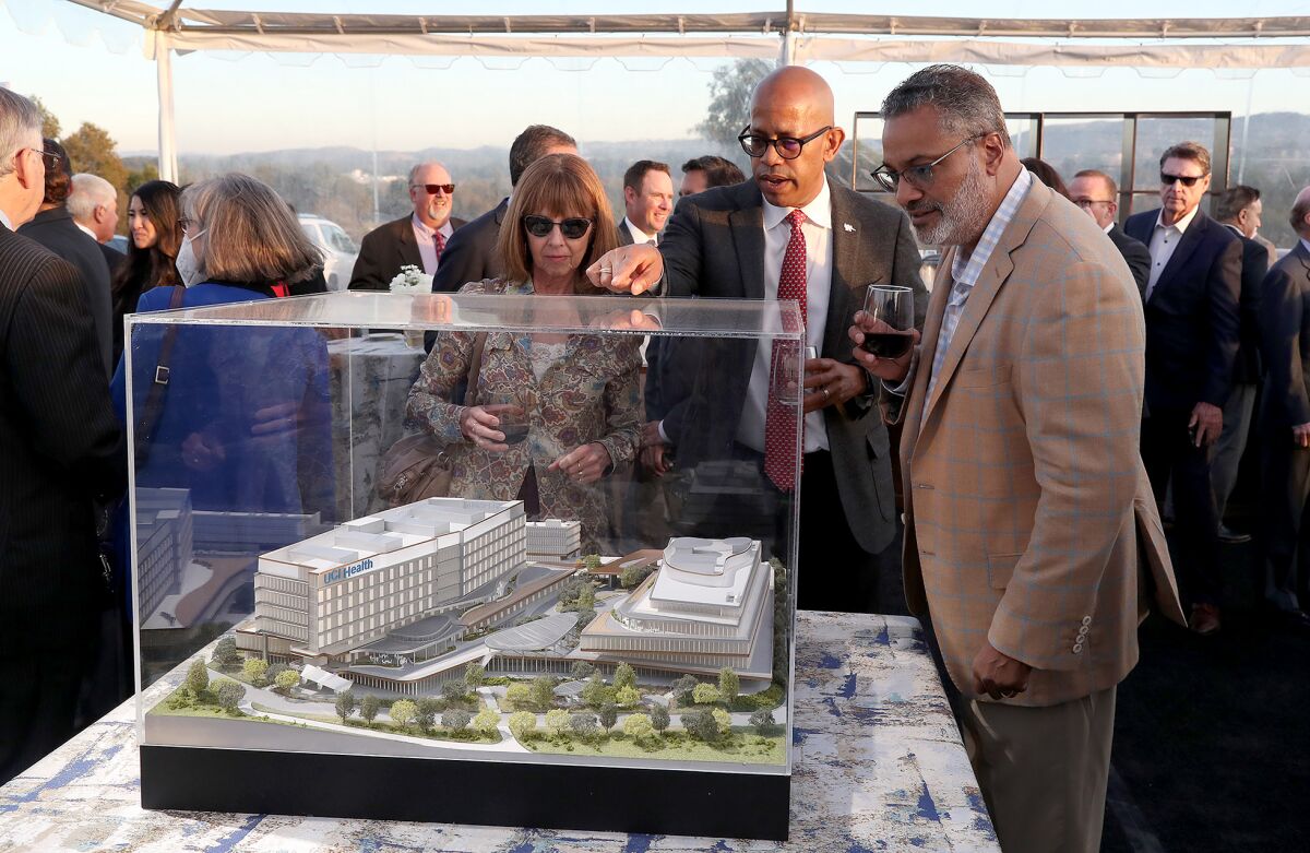 Guests Monday admire a 3D model rendering of a new UCI Health medical and academic health complex due to fully open by 2025.