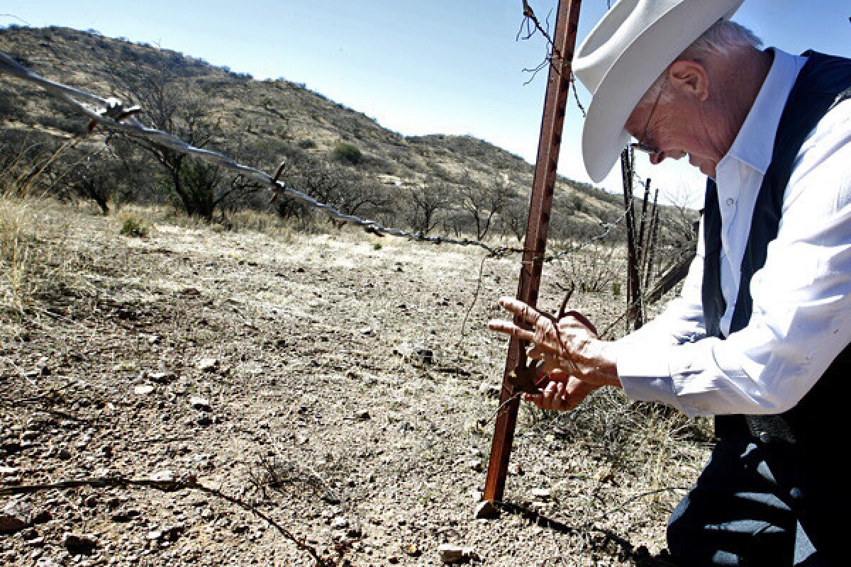 Cattle rancher Jim Chilton repairs the barbed wire fence where his ranch shares the border with Mexico about 19 miles south of Arivaca, Arizona. Cartel drug runners and illegal migrants cut the wire almost every day.