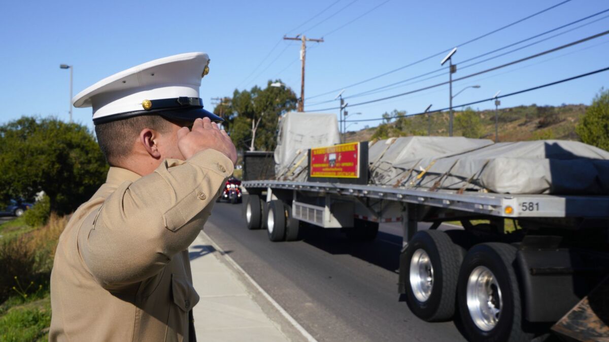 Sgt. Victor Valenzuela, from the 5th Marine Regiment at Camp Pendleton renders the hand salute as one of the trucks carrying the 5th Marines Vietnam War Memorial monument is transported on base.