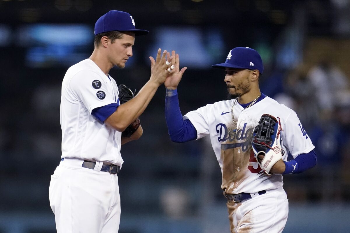 Los Angeles Dodgers' Corey Seager, left, and Mookie Betts celebrate the team's 3-2 win over the Atlanta Braves in a baseball game Tuesday, Aug. 31, 2021, in Los Angeles. (AP Photo/Marcio Jose Sanchez)