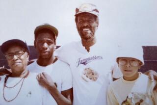 Wally Amos, of Famous Amos cookie fame, poses for a portrait with his mother and two sons in 1977.