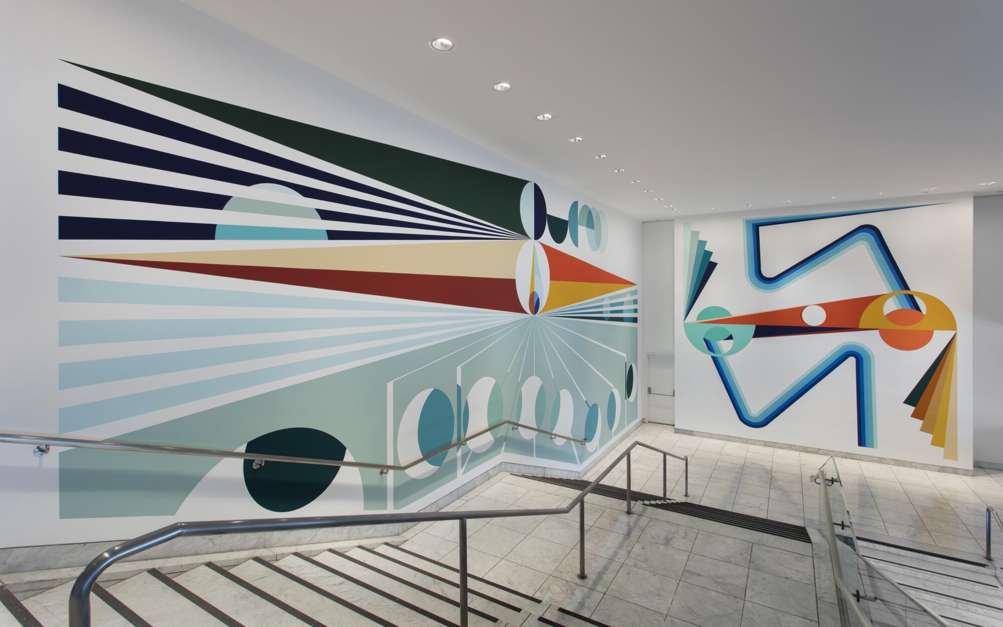 A large mural of geometric forms, including circular patterns and bands of color that evoke light, wrap around stairs