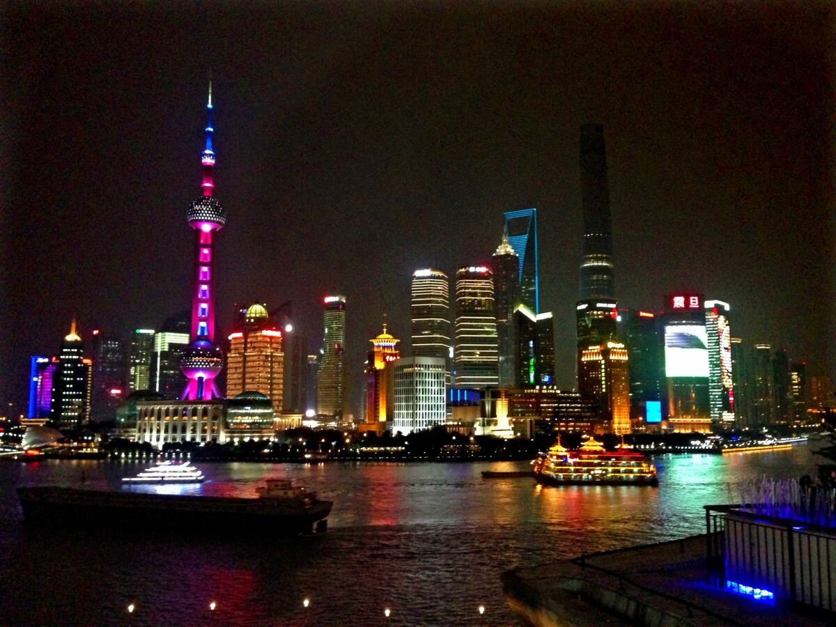 High-rise buildings in central Shanghai lighted up at night.
