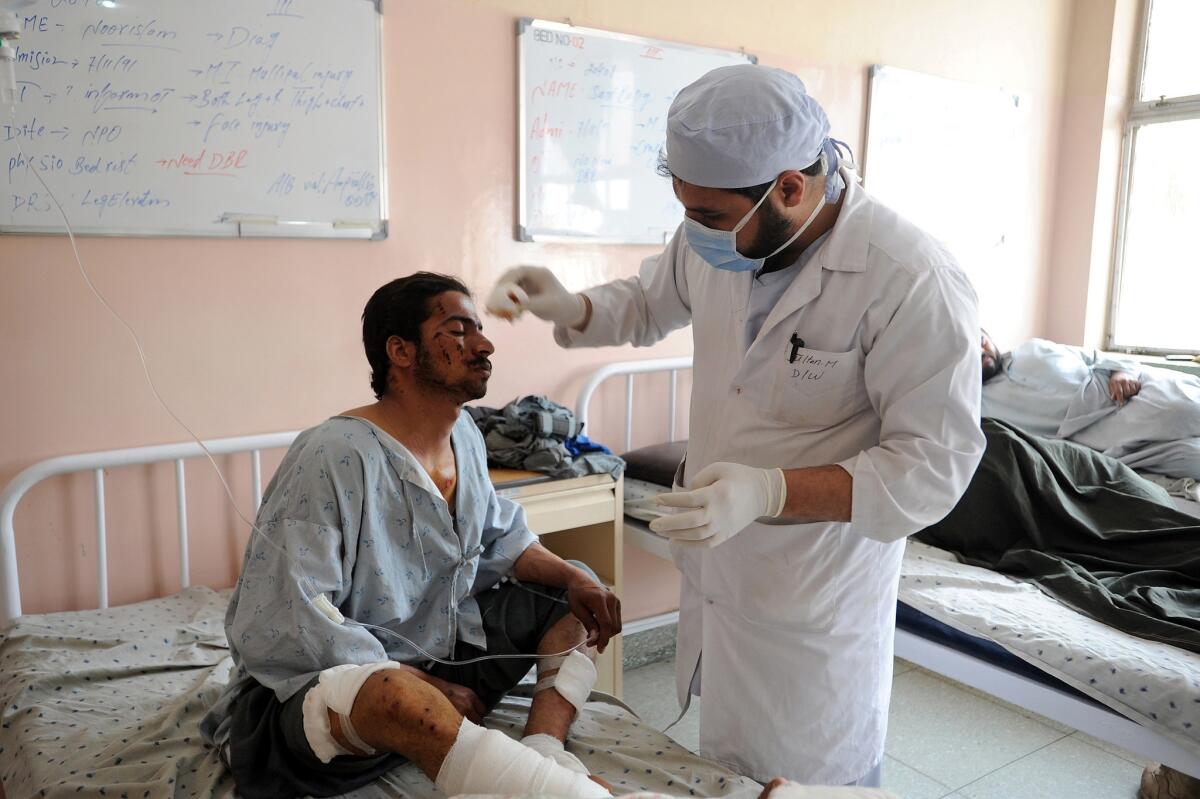 A wounded Afghan police officer is treated at a hospital in southern Afghan city of Kandahar. Eight police officers and three detainees were killed late Saturday by a powerful homemade bomb in Kandahar, officials said.