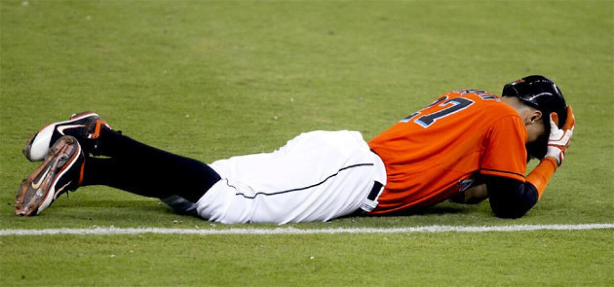 Miami Marlins' Giancarlo Stanton holds his head after straining his hamstring during a game against the New York Mets.