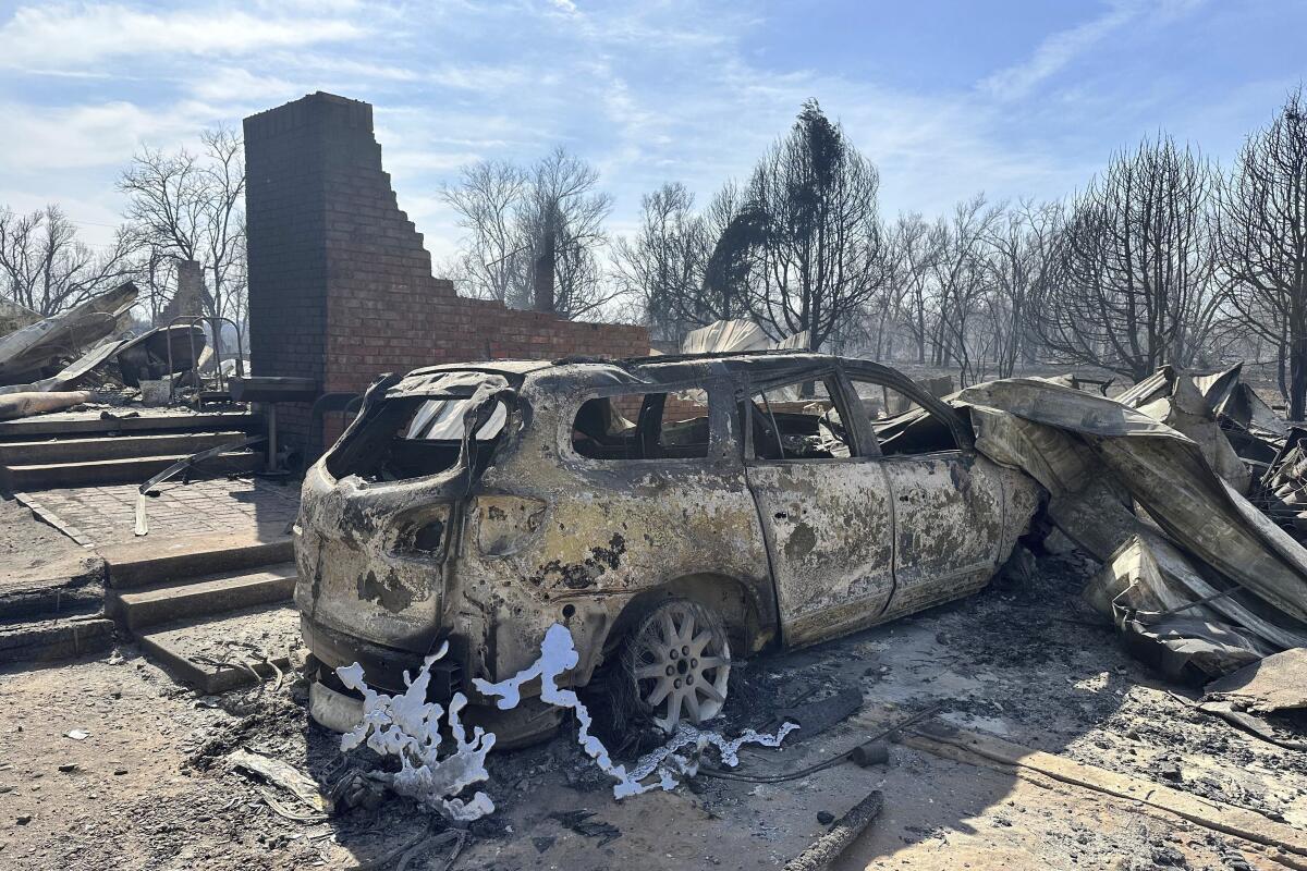 Un vehculo quemado cerca de los restos calcinados de una vivienda en las afueras de Canadian, Texas, el mircoles 28 de febrero de 2024. (AP Foto/Sean Murphy)
