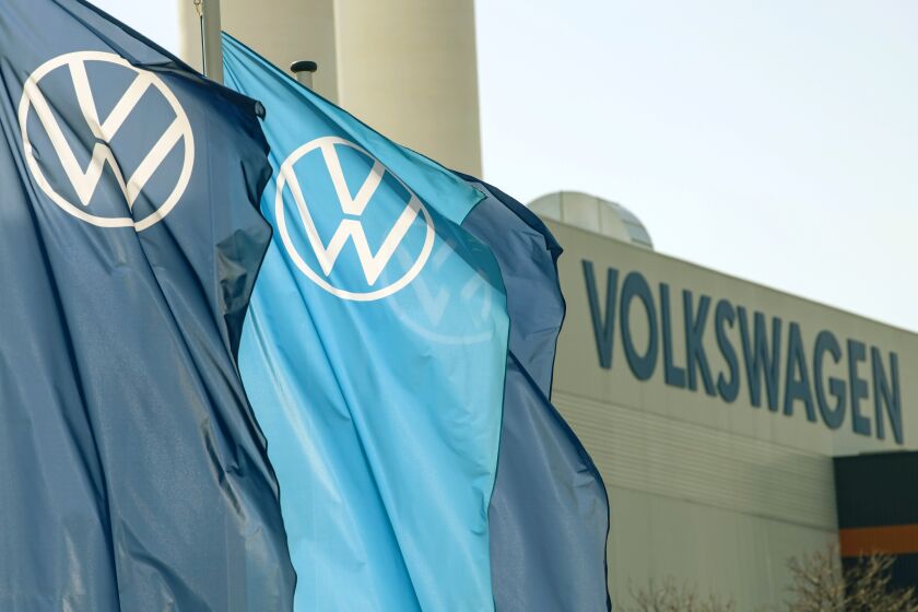 FILE - Company logo flags wave in front of a Volkswagen factory building in Zwickau, Germany, on April 23, 2020. Volkswagen was nearing the finish line Wednesday, Sept. 28, 2022, as it readied the sale of shares in luxury carmaker Porsche ahead of an expected market listing that will rank among the largest such offerings in European history. (AP Photo/Jens Meyer, File)