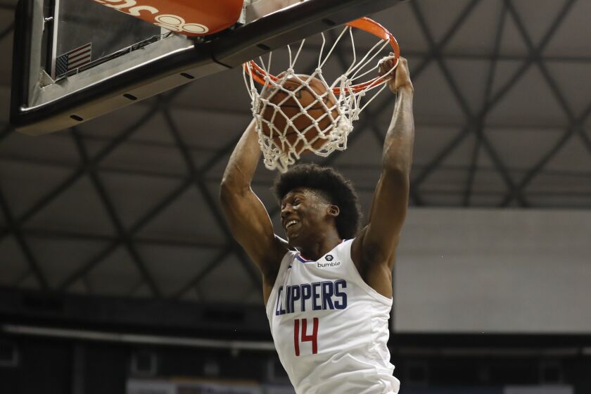 Los Angeles Clippers shooting guard Terance Mann (14) makes a slam dunk over the Houston Rockets during the third quarter of an NBA preseason basketball game, Thursday, Oct 3, 2019, in Honolulu. (AP Photo/Marco Garcia)
