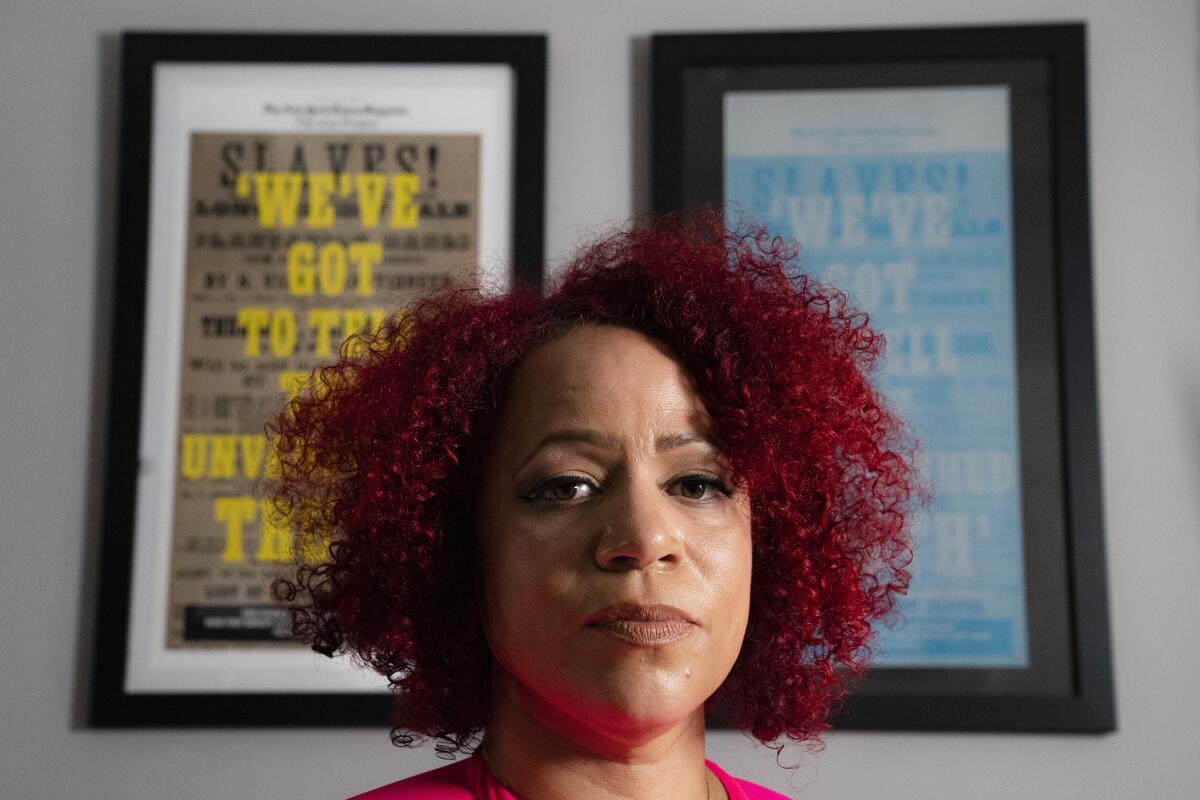 Nikole Hannah-Jones stands in front of framed images promoting the New York Times' 1619 project.