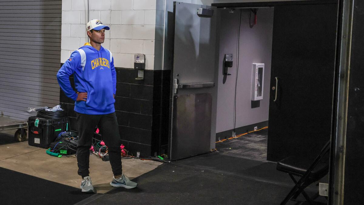 Chargers coach Brandon Staley stands in stunned silence outside the locker room after a playoff loss to Jacksonville.