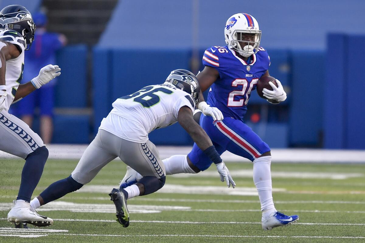 Buffalo Bills running back Devin Singletary avoids a tackles by Seattle Seahawks strong safety Damarious Randall.