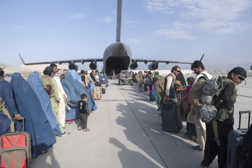 In this image provided by the U.S. Air Force, U.S. Air Force loadmasters and pilots assigned to the 816th Expeditionary Airlift Squadron, load people being evacuated from Afghanistan onto a U.S. Air Force C-17 Globemaster III at Hamid Karzai International Airport in Kabul, Afghanistan, Tuesday, Aug. 24, 2021. (Master Sgt. Donald R. Allen/U.S. Air Force via AP)